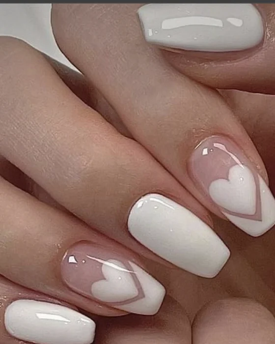Ongles blancs brillants avec un coeur en contour, vus de plus près
